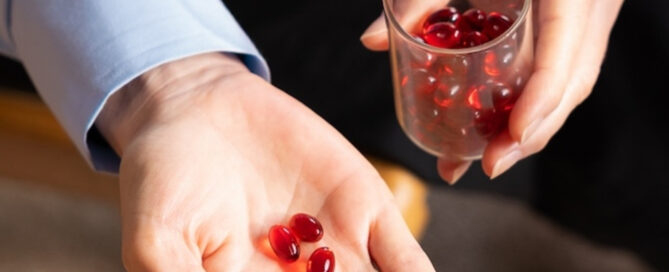 Krill oil omega-3 supplement capsules held in a hand, illustrating nutraceutical ingredients distributed by SK Chemtrade